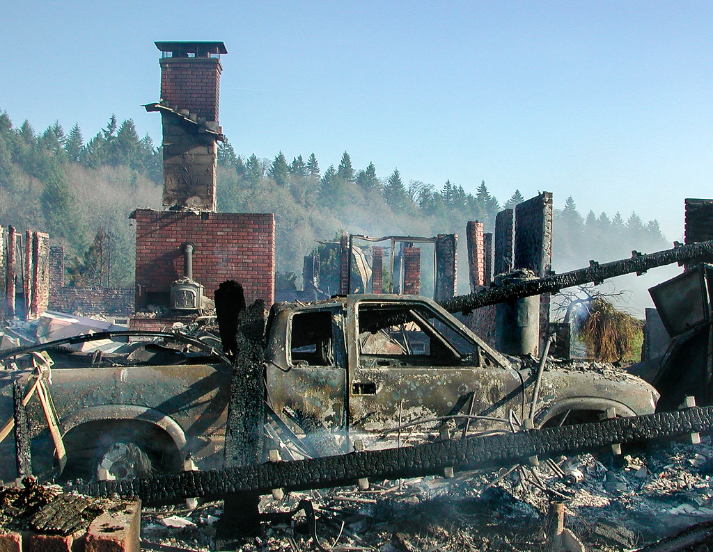 Destroyed structure and debris aftermath from wildfire and fire damage
