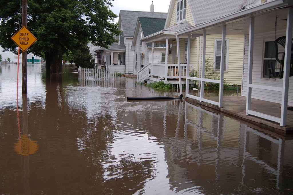 Floodwater reaching the doorsteps of residential homes on a suburban street during a major flooding event