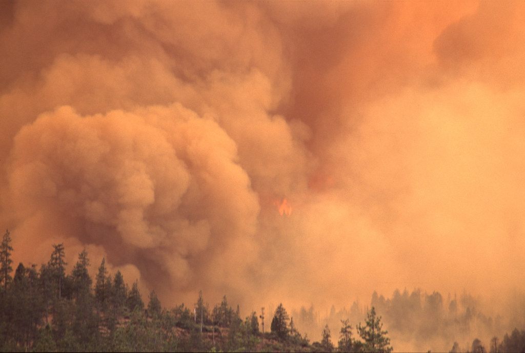 Wildfire smoke drifting across a dry hillside in Utah during storm season